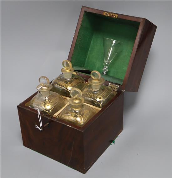 A George III mahogany cased set of four gilded glass decanters and a glass, with key